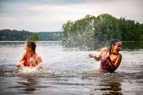 Naiset järvessä uimassa ja roiskimassa vettä toistensa päälle